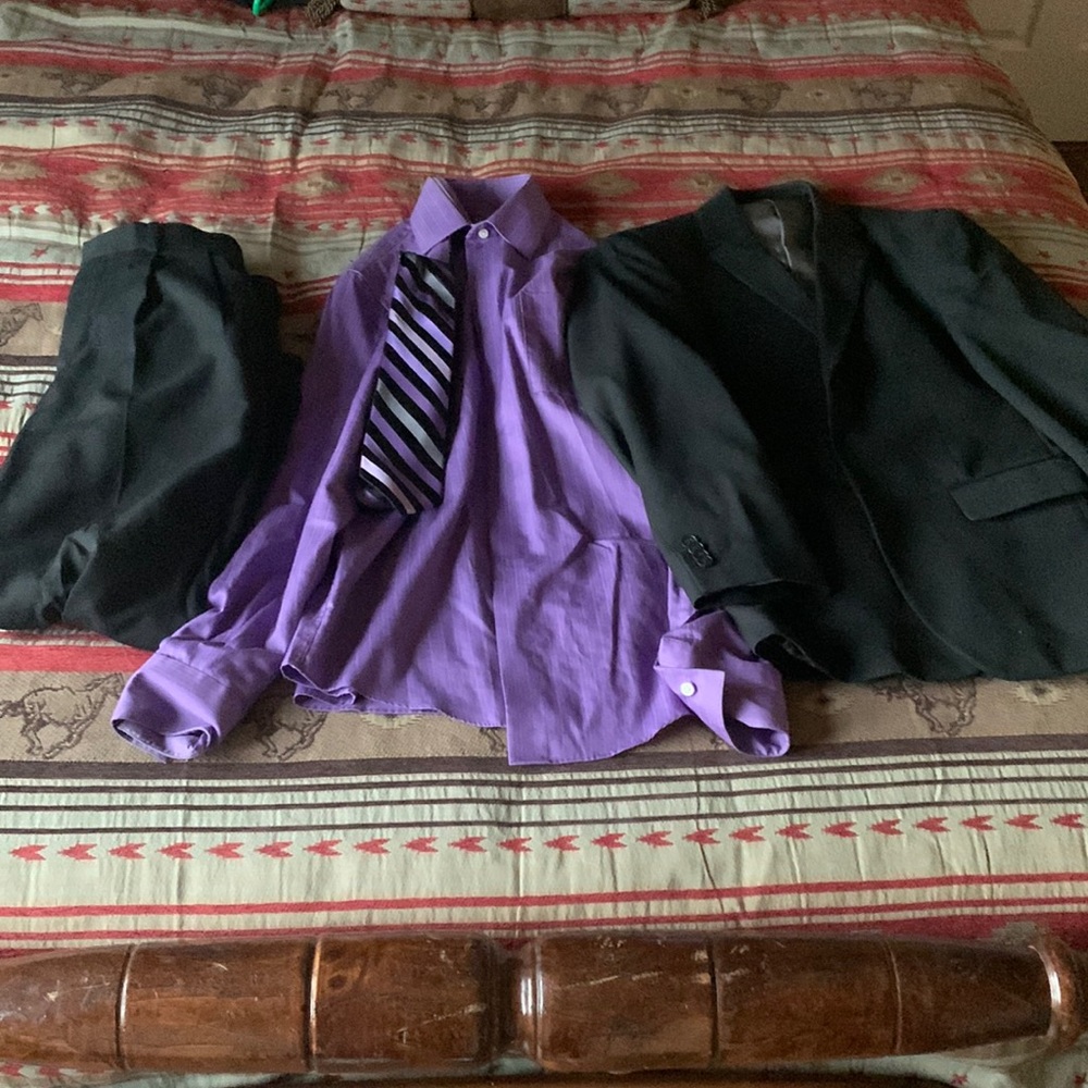 Black dress pants, purple dress shirt with purple tie, and dress coat